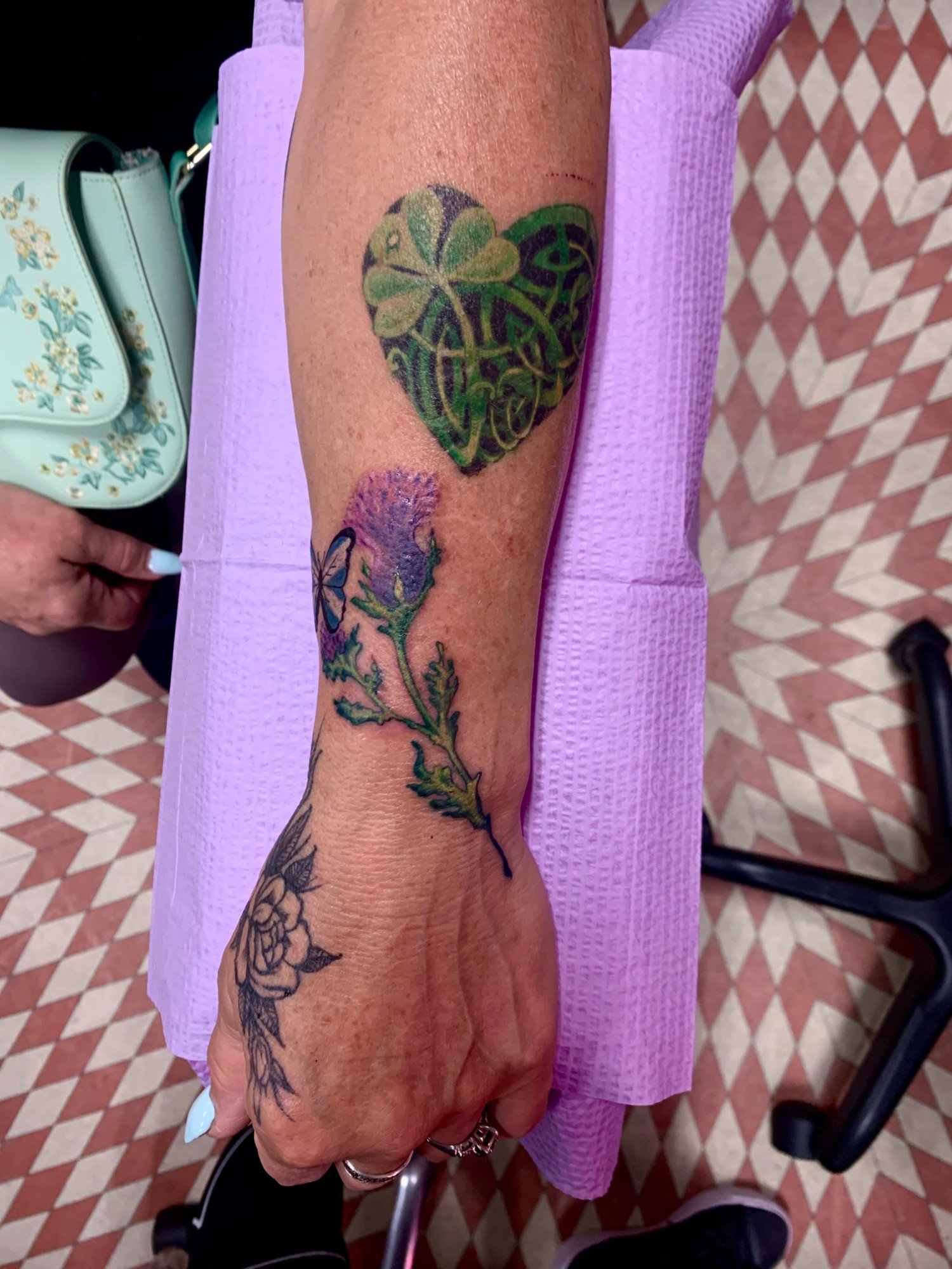 Thistle with butterfly next to a shamrock heart tattoo